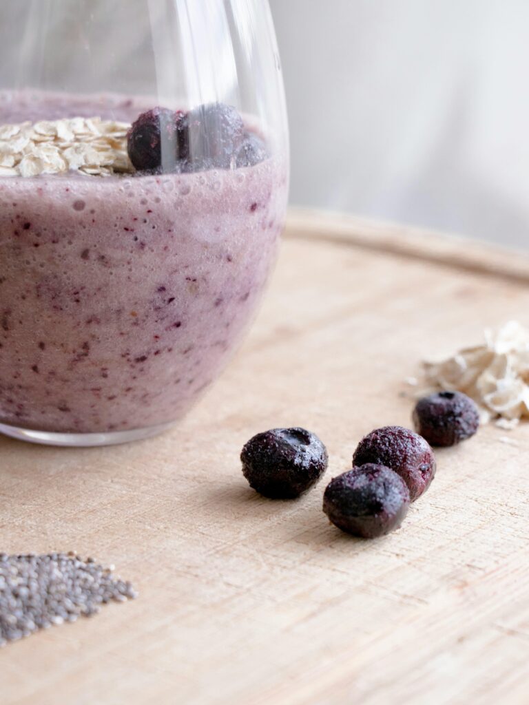 Close-up of a healthy blueberry and chia seed smoothie with oats in a glass.