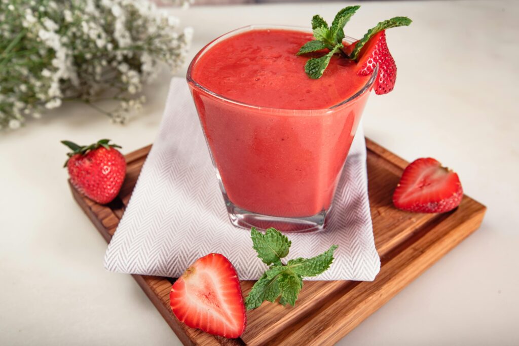 Delicious strawberry smoothie with mint garnish on wooden tray at Dubai café.